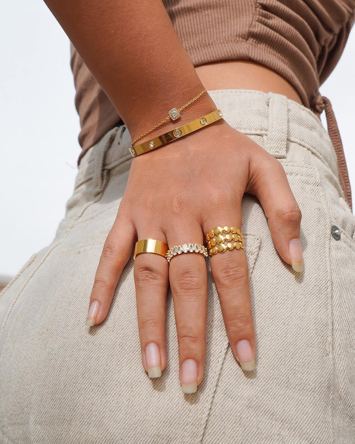 Rings — hand wearing stacked gold-plated rings and bracelets from Banana & Kale