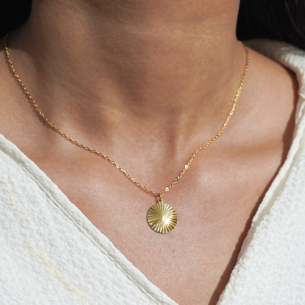 Insurgent — disc pendant worn at the collarbone
