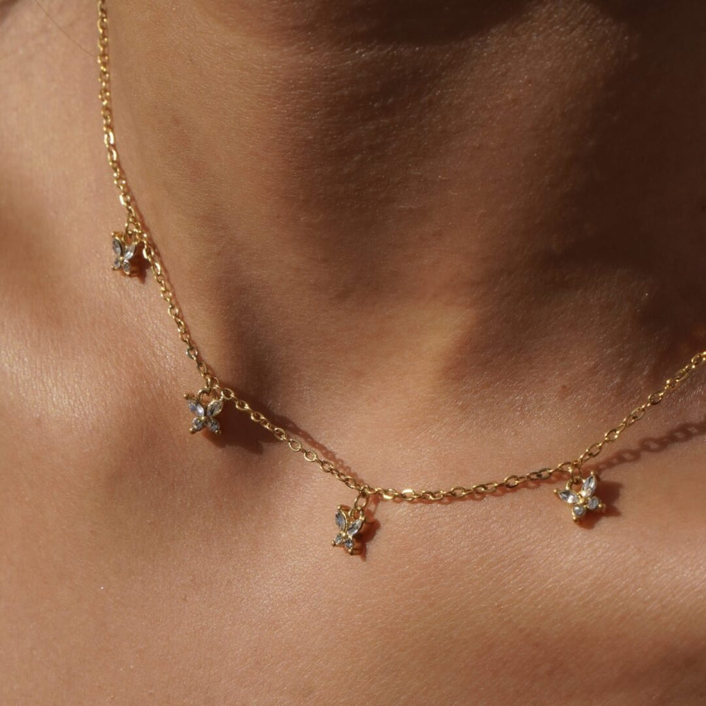 Flutter — close-up of zircon-set butterfly detail on fine gold chain