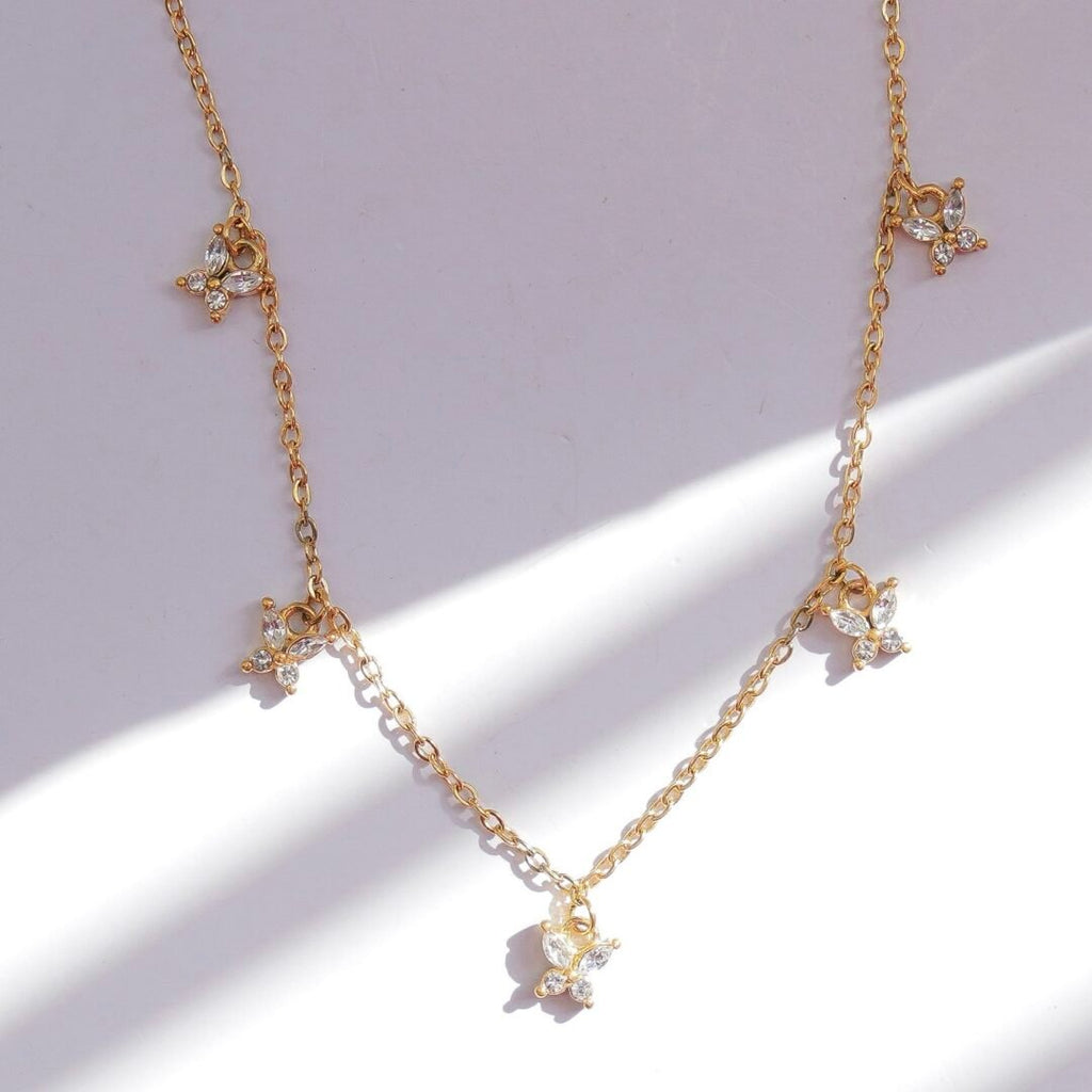 Flutter — gold-plated butterfly necklace worn at the collarbone