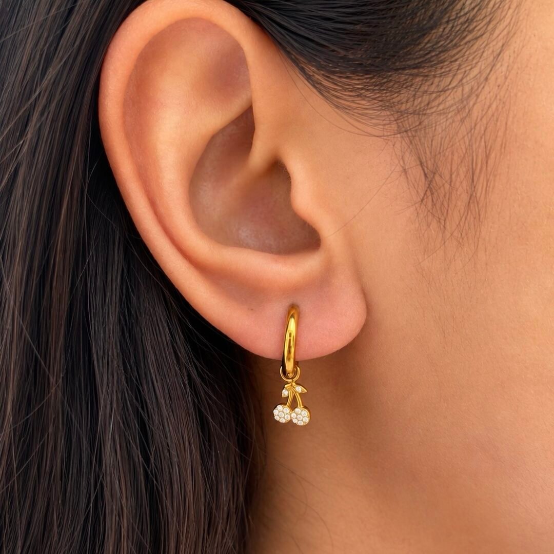 Cherry Huggies — gold-plated cherry huggie earrings worn on the ear