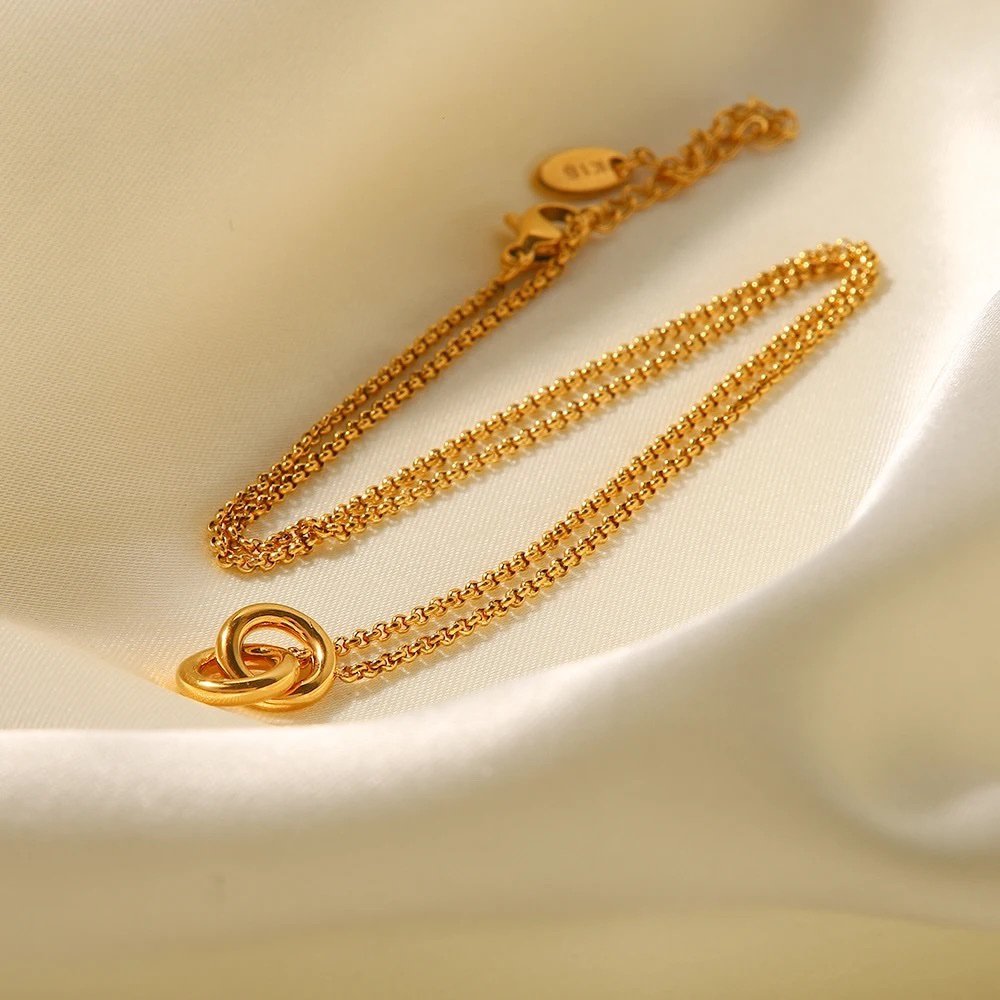 Intertwined — gold-plated pendant necklace on chain, flat lay