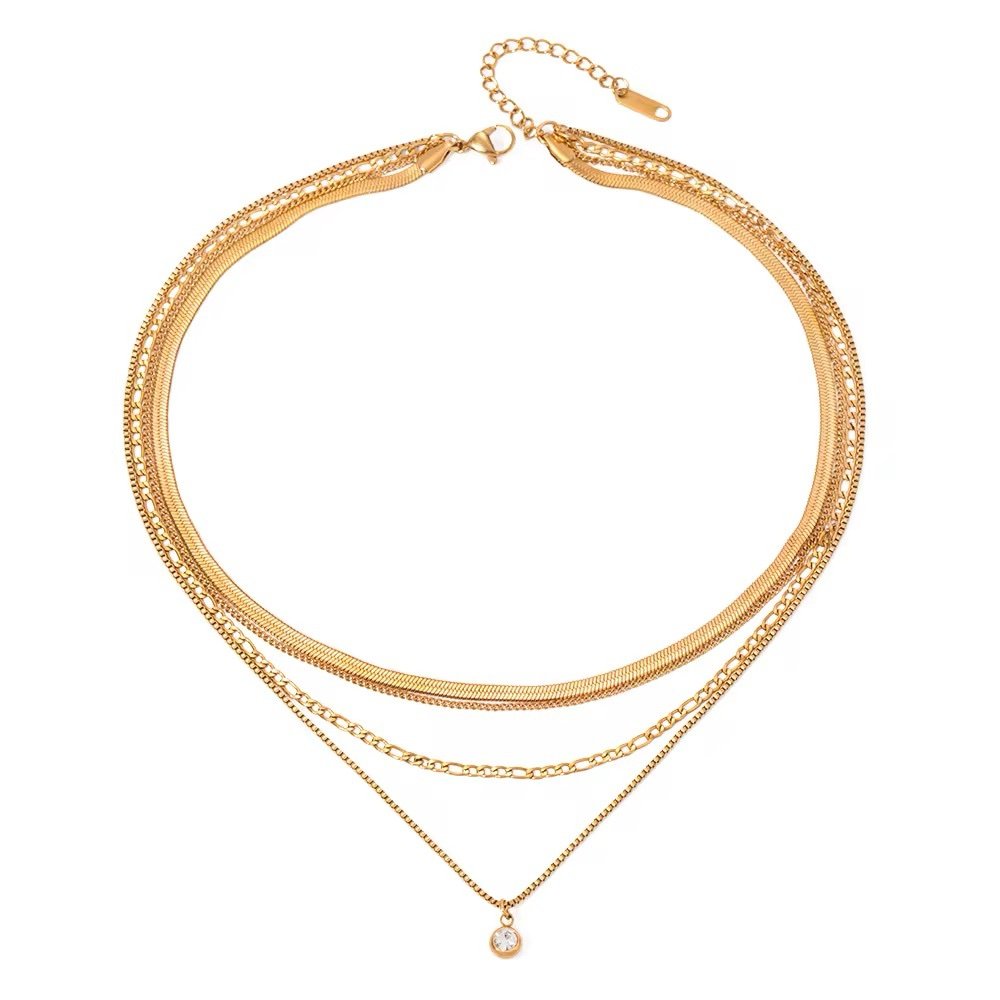 Four Layered Gem Necklace — four gold chains with a bezel-set zircon drop, flat lay