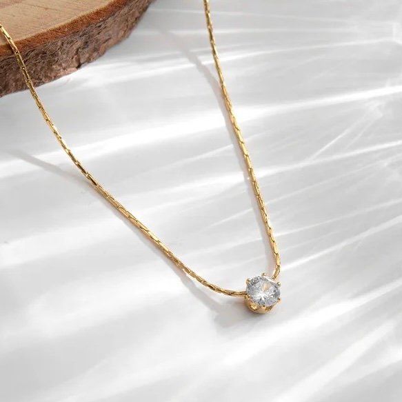 Glitz — zircon pendant necklace styled flat lay