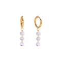 Twinkle Huggies — gold huggie hoops with a drop of three round zircons, front view